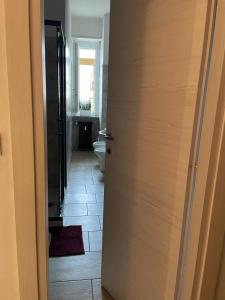 una puerta abierta a un baño con aseo en H&R's Room, en Turín