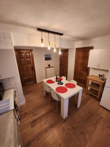 een keuken met een witte tafel met rode borden erop bij Apartamento rural in Pravia