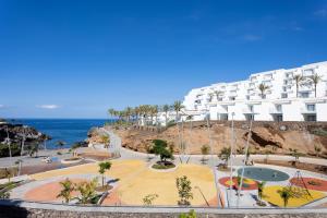 a large white building next to the ocean at Ocean View Sunset in Adeje
