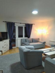 a living room with a couch and a tv at Villa Ramea in Kovačevo Polje