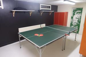 a ping pong table in a room with a tennis court at Spacious house with sauna 2 bathrooms and indoor pingis table! in Hestra