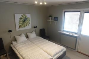 een slaapkamer met een bed met witte lakens en een raam bij Spacious house with sauna 2 bathrooms and indoor pingis table! in Hestra
