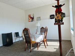 - une salle à manger avec une table et un panneau de bienvenue dans l'établissement Peaceful and Spacious Lake View, à West Kelowna