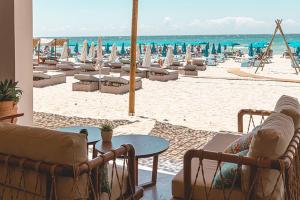 a beach with a bunch of lounge chairs and the ocean at Tsokkos Paradise Holiday Village in Ayia Napa