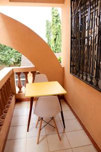 uma mesa amarela e duas cadeiras numa varanda em Kache's homes em Mombasa