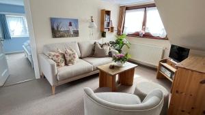a living room with a couch and a table at Haus Boy Jensen Wohnung Dünenblick in Wenningstedt