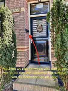 una puerta con una cinta roja delante de ella en De Stadshoeve, en Medemblik