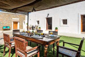 a wooden table in the middle of a patio at Villa Can Pep D'en Puig in Sant Mateu d’Albarca