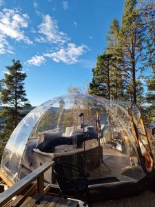 a boat in a glass dome on a deck at Glassigloo med panoramautsikt - Nordlys og stjernehimmel - Fosen in Husby