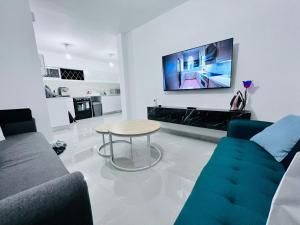 a living room with a couch and a table and a tv at New! Your home in Israel Luxury Suite in Bat Yam