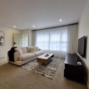 a living room with a couch and a tv at Inner City 2 Bedroom Unit in Hamilton