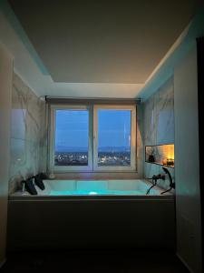 a bathroom with a bath tub with a window at The Skyline Suite in Florina