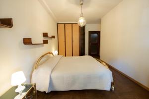 um quarto com uma cama branca e um candeeiro em Elegante appartamento di 200 mq con vista a Sanremo em Sanremo