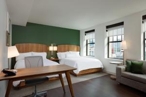 1 dormitorio con cama, escritorio y silla en Element Detroit at the Metropolitan en Detroit