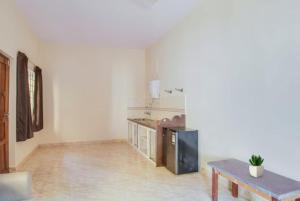 un soggiorno con tavolo e cucina di Joel's River Wood a Pernem