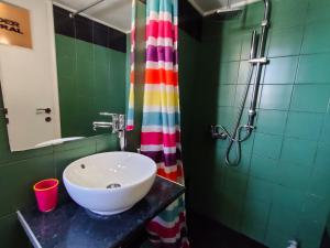 a bathroom with a sink and a rainbow shower curtain at Studio in Athens center in Athens