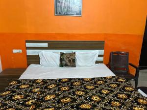 a bedroom with a bed with an orange wall at Hotel Blue Star in Haldwāni