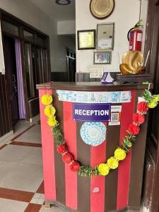 a red white and yellow reception counter with flowers on it at Hotel Blue Star in Haldwāni