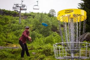a woman throwing a frisbee in front of a metal object at Sirdal fjellpark in Tjørhom
