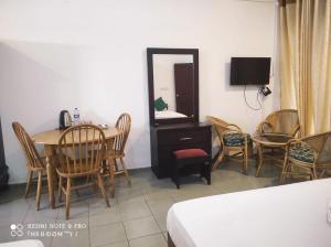 a room with a table and chairs and a mirror at Oasis Beach Resort in Negombo