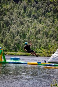 un hombre está saltando de una balsa en el agua en Sirdal fjellpark en Tjørhom