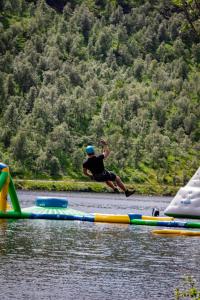 a man is jumping off of a raft in the water at Sirdal fjellpark in Tjørhom
