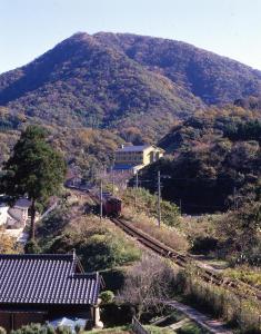 a train on the tracks in front of a mountain at Kouragi in Kami