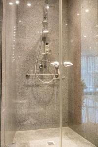 eine Dusche mit einer Glastür in einem Badezimmer in der Unterkunft Exklusive Stadtoase Design·Wohnung · Panoramablick in Koblenz