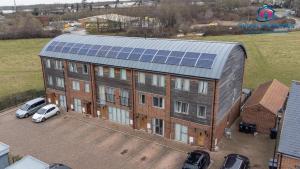 um grande edifício de tijolos com painéis solares no telhado em Comfy Casa - Syster Properties Serviced Accommodation Leicester Families, Work, Groups - Sleeps 13 em Leicester