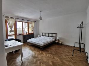 a bedroom with a bed and a table in it at Evergreen Condo in Braşov