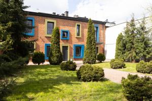een stenen huis met blauwe ramen en struiken bij FILMOWA KAMIENICA in Łódź