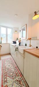 eine Küche mit einer Spüle und einer Arbeitsplatte in der Unterkunft Le Beffroi : appartement cosy en cœur de ville in Armentières