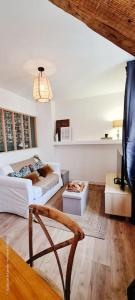 ein Wohnzimmer mit einem Sofa und einem Tisch in der Unterkunft Le Beffroi : appartement cosy en cœur de ville in Armentières