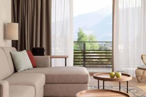 un soggiorno con divano e una grande finestra di Hotel Schwarzschmied a Lana