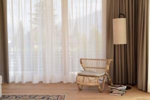 a chair and a lamp in a room with a window at Hotel Schwarzschmied in Lana