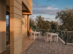 un patio con mesas y sillas en el balcón en La Volpe e la Stella by Podere Carriero en Montescaglioso