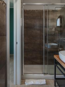 La salle de bains est pourvue d'une douche en verre et d'un lavabo. dans l'établissement La Volpe e la Stella by Podere Carriero, à Montescaglioso