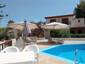 a villa with a swimming pool and a house at Alexandros Studios in Kalamaki