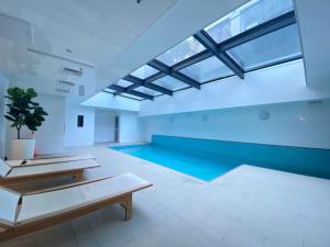 a large swimming pool with a large skylight at City and view holiday home in Auckland