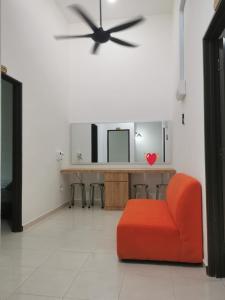 a living room with a red chair and a mirror at cs homestay in Kuantan