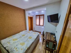 a bedroom with a bed and a desk and a television at Gurman in Strumica