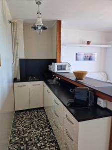 a kitchen with white cabinets and a black counter top at Apartamentos Wundermar in Torredembarra