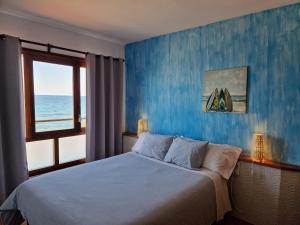 a bedroom with a bed with a blue wall at Apartamentos Wundermar in Torredembarra