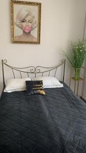 a bed with a picture of a woman on the wall at Golden Apartament Legionów in Toruń