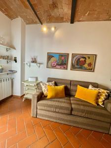 ein Wohnzimmer mit einem Sofa und gelben Kissen in der Unterkunft Maila Apartments 25min from Florence in Prato