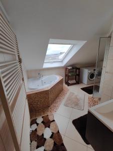ein Badezimmer mit einer Badewanne und einem Dachfenster in der Unterkunft Luxuriöse Ferienwohnung, Vorort von Saarbrücken in Saarbrücken