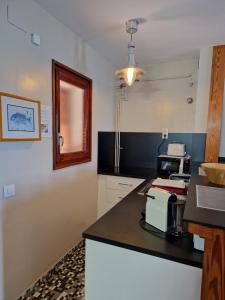a kitchen with a black counter top and a microwave at Apartamentos Wundermar in Torredembarra