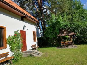 a white house with a red door and a gazebo at Wigierska Chatka in Gawrych Ruda