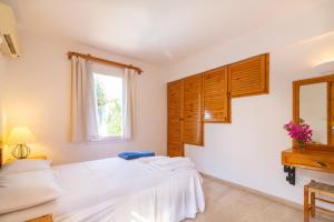 a bedroom with a white bed and a window at Korsan Apartment No.5 in Kaş