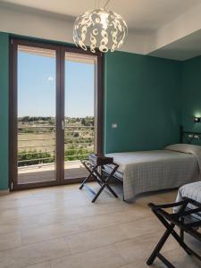 a bedroom with a bed and a large window at La Volpe e la Stella by Podere Carriero in Montescaglioso